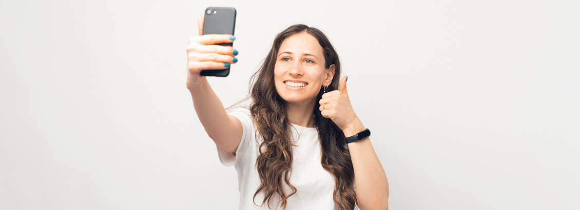 Mujer Grabando Reel en Instagram desde Smartphone para Mostrar la Evolución de su Marca