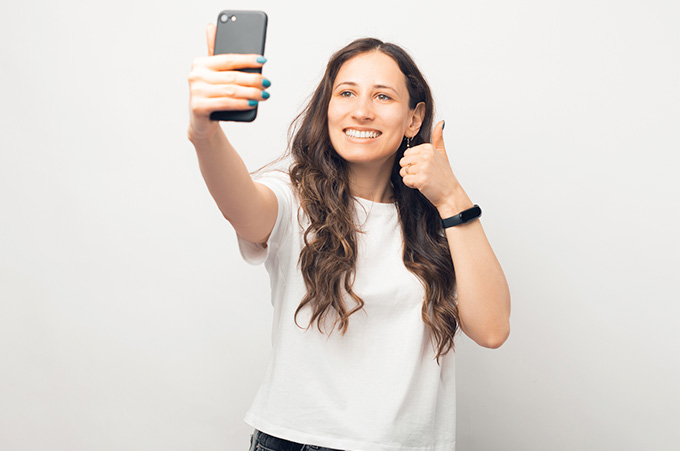 Mujer Grabando Reel en Instagram desde Smartphone para Mostrar la Evolución de su Marca