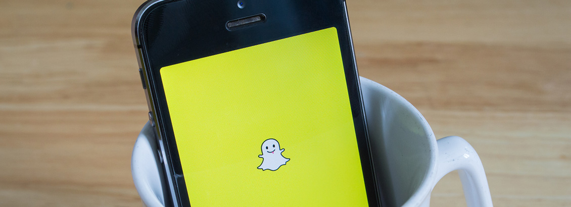 Smartphone, Dentro de Taza de Café Blanca, que Muestra Snapchat en su Pantalla