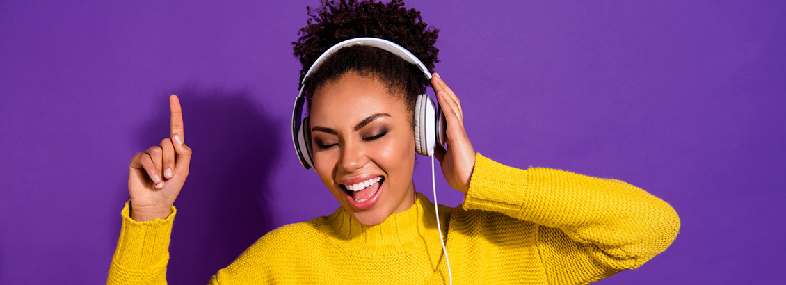 Mujer Sonriendo Mientras Escucha Música desde sus Auriculares