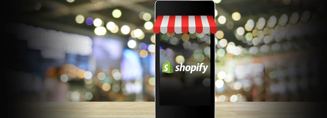 Smartphone con Accesorios de Tienda y el Logo de Shopify en la Pantalla
