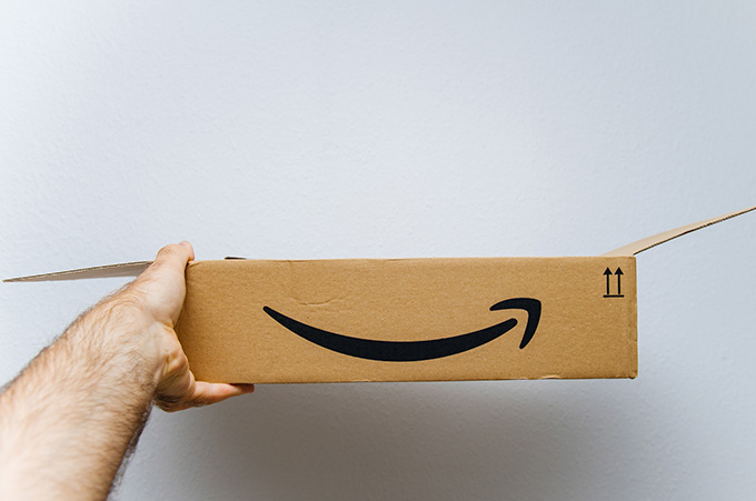 Mano Sosteniendo Caja Abierta con Logo de Amazon