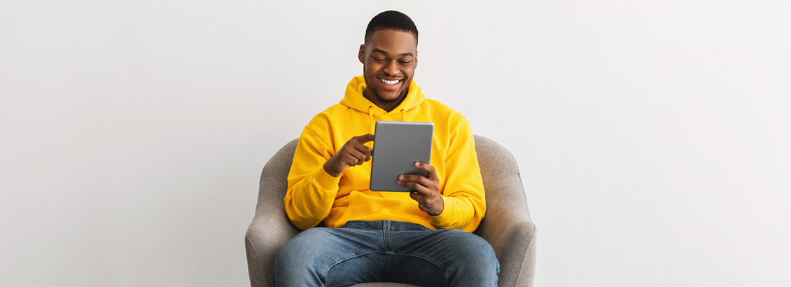 Hombre Sentado y Soriente con su Tablet Vendiendo por Instagram